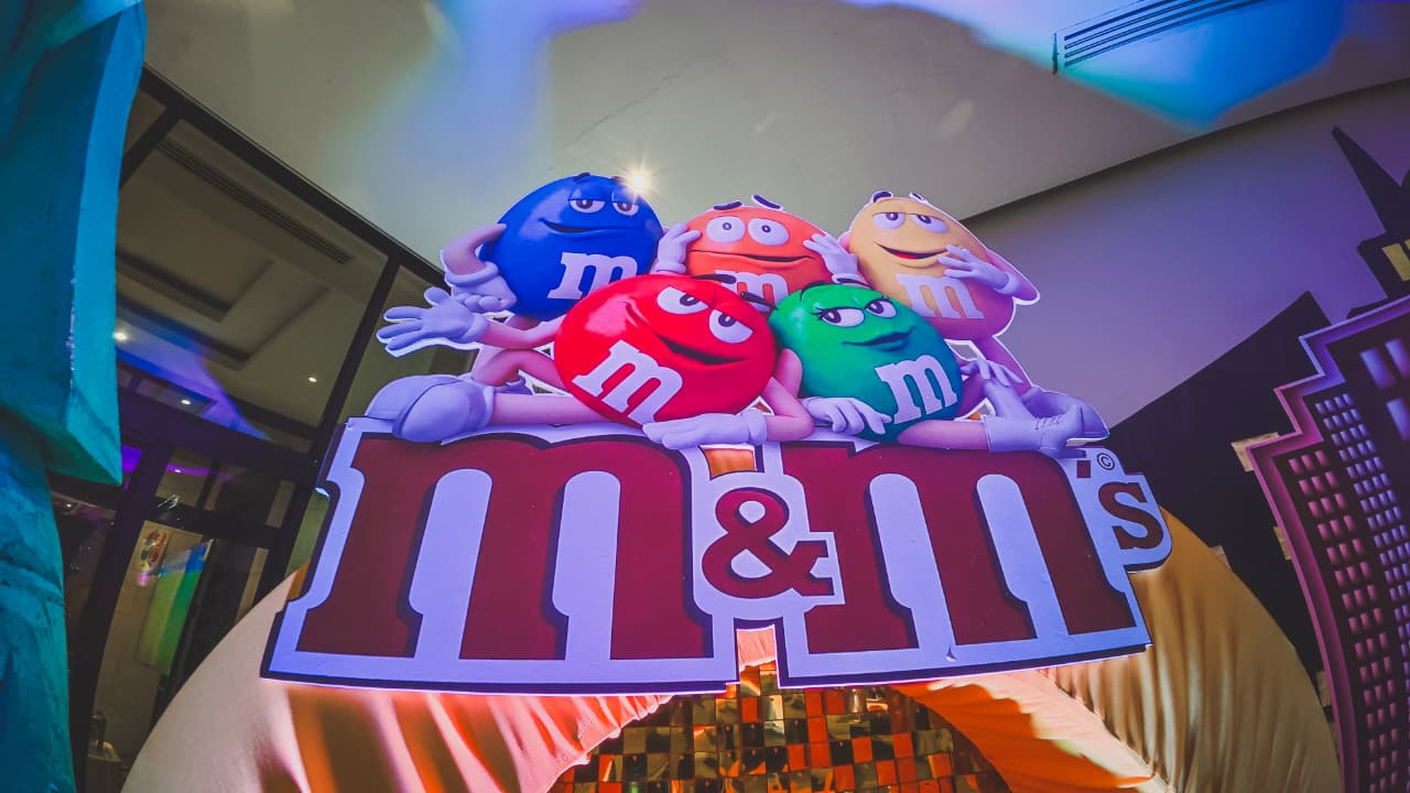 Letrero gigante de M&M’s iluminado sobre el arco de la estación de dulces