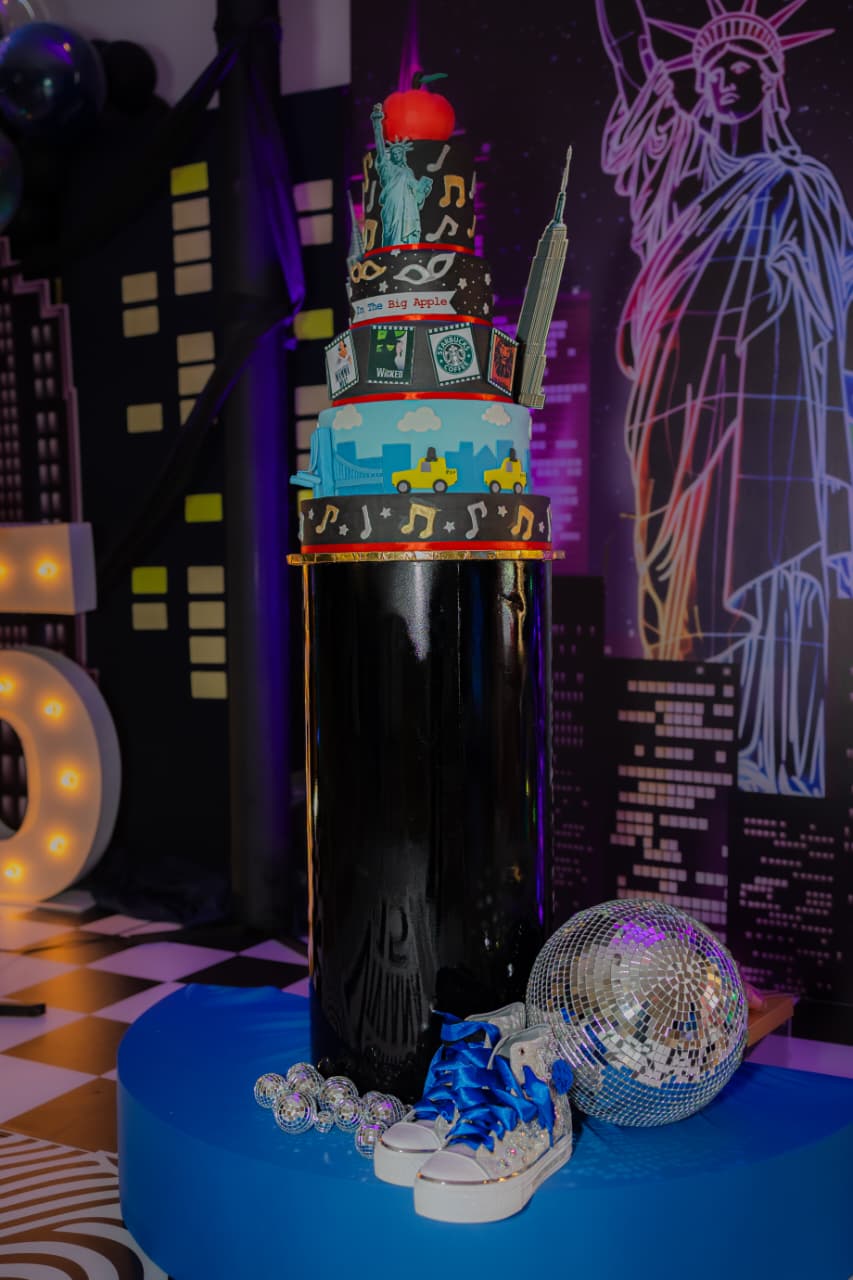 Pastel de pisos temático de New York junto a esfera disco y zapatillas con cristales